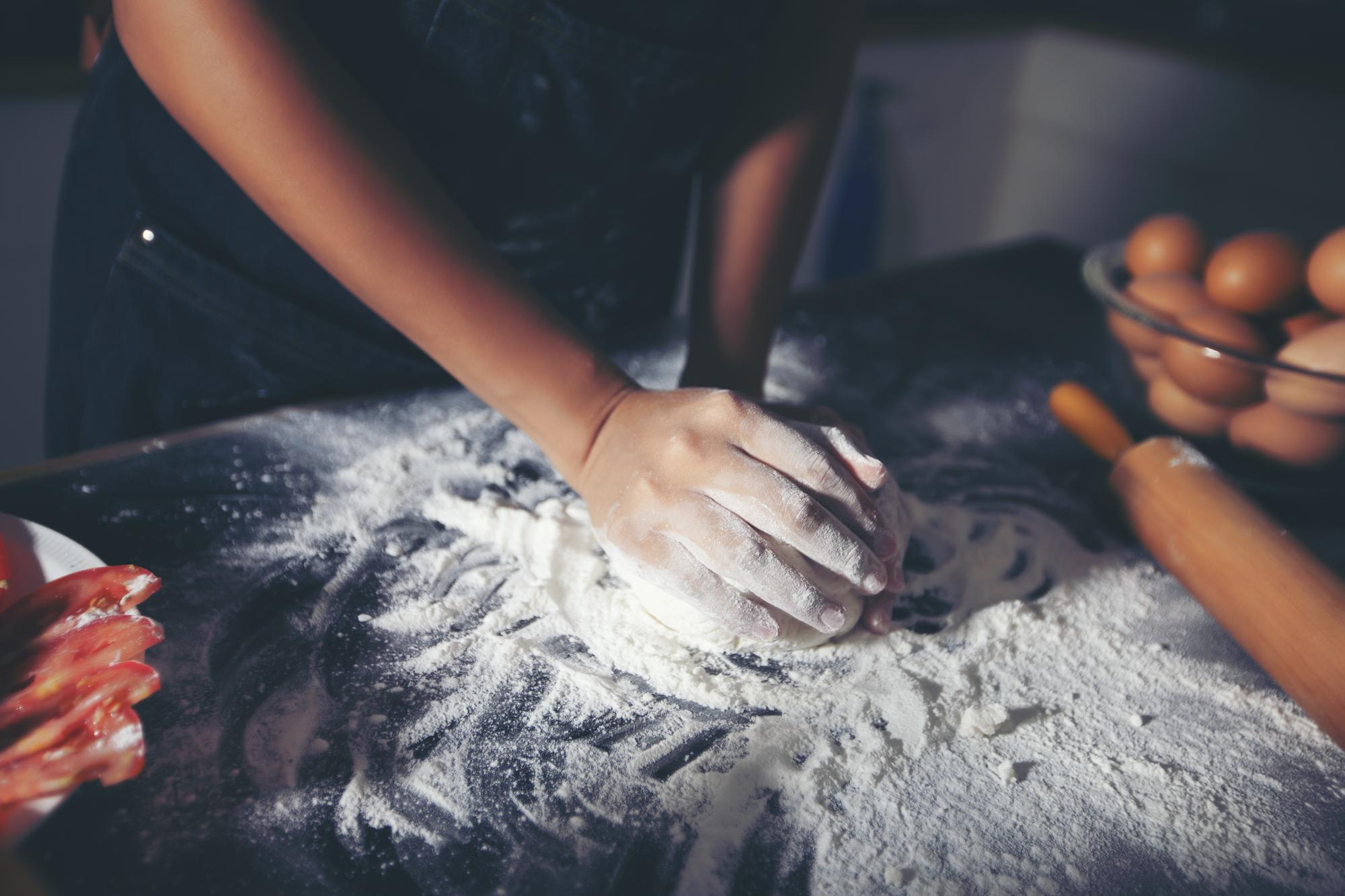Hands preparing dough in a small bakery